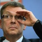 Matolcsy György szemüvegben a kezével fogja és grimaszol kicsit