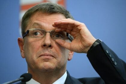 Matolcsy György szemüvegben a kezével fogja és grimaszol kicsit