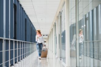 nő bőrönddel sétál a reptéren