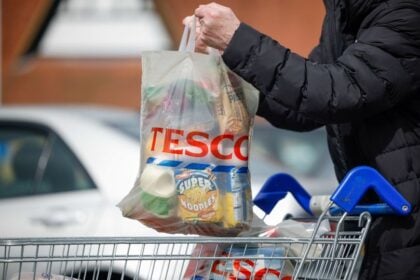 tesco vásárlás ember fekete vastag kabátban bevásárlókocsi autó