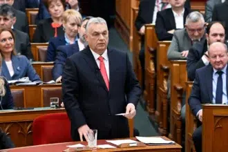 Orbán Viktor a parlamentben beszél zakóban és nyakkendővel emberek a háttérben