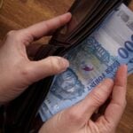 1000 forintos bankjegy egy pénztárcában, amit kivesz abból egy ember, csak a kézfeje látszik