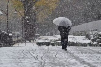 havazásban sétáló ember esernyővel