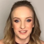 Bogdán Blanka, Szandi lánya mosolyogva, sminkben, szőke félhosszú hajjal beszél a kamerába.