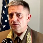 Böröndi Gábor katonai ruhában, fáradt, ráncos arccal, mikrofonba beszél.