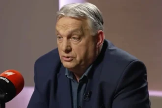 Orbán Viktor kék zakóban, zöld ingben, ősz hajjal, ráncos homlokkal, fáradtan beszél.